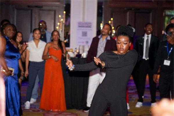  A group of people dance wearing evening gowns and suits. 